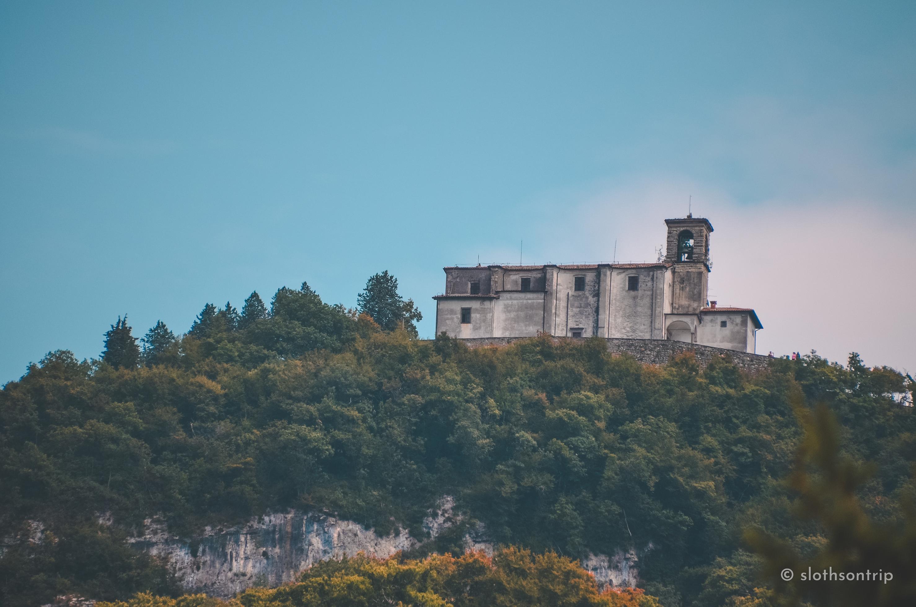 Santuario della Madonna della Ceriola – szczyt Monte Isola Położone na 600 m n.p.m. Santuario della Madonna della Ceriola góruje nad Monte Isola, oferując panoramiczne widoki na Lago d’Iseo. Skromna, kamienna bryła sanktuarium i dzwonnica kontrastują z zielenią lasu i bielą wapiennych skał, tworząc niezwykły punkt pielgrzymkowy i widokowy.